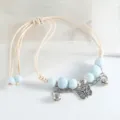 Bracelet tressé en perles de céramique bleu clair avec charms papillon et cloche argentés, réglable. - Perle ronde papillon (bleu clair)