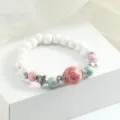 Chinese style ceramic bead bracelet with pink green accents and silver star spacers. - Cyan Glaze