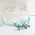 Bracelet en perles de céramique turquoise fait main avec jolis charmants papillon et cloches. - Perle ronde papillon (bleu eau)
