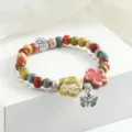 Braccialetto di perle in ceramica fatto a mano con ciondoli floreali stile etnico. - Sogno di fiori e farfalle (giallo e rosa)