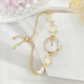 Elegant gold women watch bracelet with star and moon charms and mother of pearl dial details. - Drawstring Style (2026310) / Gold White