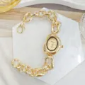Primo piano dettagliato di orologio da donna dorato irregolare con bracciale a catena spessa. - Oro