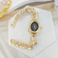 Vista dettagliata di un orologio da donna al quarzo con catena dorata irregolare e quadrante. - Oro Nero