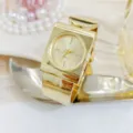 Gold square bangle watch for women, stylish minimalist cuff quartz wristwatch with metallic finish. - Gold