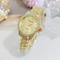 Close-up detail of a luxurious gold quartz wristwatch featuring sparkling rhinestones on the bezel. - Gold