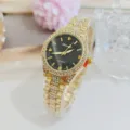 Detail gros plan de montre quartz strass doree femme avec un cadran noir elegant. - Or Noir