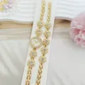 Gros plan sur les détails exquis du set montre et bracelet fleurs strass dorés scintillants. - Rose