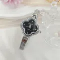 Close-up detail van dames quartz horloge met klaverblad wijzerplaat en zilveren mesh armband. - Zilver Zwart