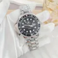 Men's quartz watch detail, stainless steel strap, black dial with date window and GMT bezel. - Silver Black