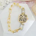 Detailed shot of a luxury square leopard print quartz women watch with linked bracelet. - Gold Leopard