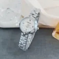Close-up of women's quartz watch with Roman numerals and silver metal strap detail. - Silver White
