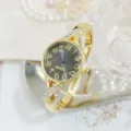 Close-up detail van de gouden dames strass armband horloge wijzerplaat met fonkelende band. - Goud Zwart