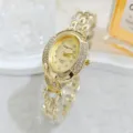 Close-up of a vintage luxury oval rhinestone quartz watch with a gold chain bracelet. - Gold