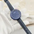 Women quartz watch with blue leather strap, rhinestone markers and elegant floral dial. - Blue