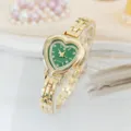 Primo piano dell'elegante orologio al quarzo dorato a cuore con quadrante verde e cinturino chic. - Oro Verde