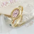 Retro oval quartz watch for women with pink dial Roman numerals and stylish gold bangle strap. - Regular Fit / Pink