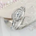 Detailed view of silver oval bangle quartz watch with elegant white Roman numeral dial. - Regular Fit / Silver White