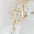 Primo piano di orologio bracciale quadrato dorato al quarzo, elegante quadrante bianco romano. - Stile a Scala Romana / Oro Numeri Romani