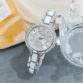 Detail view of a luxury women rhinestone quartz watch with elegant white link strap and dial. - Silver White