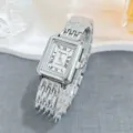 Close-up detail of silver rectangular quartz watch featuring Roman numerals and metal bracelet. - Silver White
