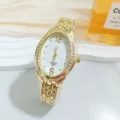 Detailansicht einer luxuriösen goldenen Damenuhr mit Quarzwerk und funkelnder Strasslünette. - Gold Weiß