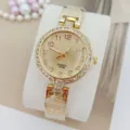 Elegante goldene Damen-Quarzuhr mit Strasslünette, Zifferblatt und stilvollem Herzarmband. - Gold