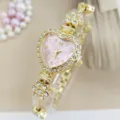 Nahaufnahme Detail der luxuriösen Damen Herz Strass Quarz Uhr mit goldenem Blumenarmband. - Gold Violett