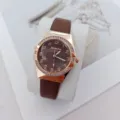 Detailed view of women quartz wristwatch featuring brown leather strap and rhinestone bezel. - Brown