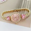 Close up view of women pink dial quartz watch featuring elegant heart diamond and gold chain. - Gold Pink