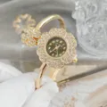 Vue détaillée d'une montre bracelet dorée en strass floral, superbe design cristal. - Or Vert