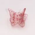 Close-up detail of a cute mini butterfly hair claw clip with pink glitter jelly design for styling. - 2.0cm / Pink