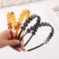 Detailed close-up of plastic leaf hair bands with rhinestones, showing amber and black variants. - 16cm Glossy Black Headband with Rhinestones K1510-L005/57
