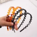 Detailed shot of wavy zigzag headbands with sparkling rhinestones, black and amber colors. - 16cm Glossy Black Headband with Rhinestones K1521-L005/57