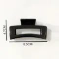 Detail view of the glossy black rectangular hollow plastic hair claw clip with specs. - Hair Claw (Z1955) / 8.6cm / Bright Black