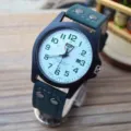 Matte military watch with green leather strap, clear dial and calendar. Detail view of watch. - Green