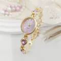 Detailed closeup of the elegant women quartz watch featuring purple waterdrop crystals and gold. - Purple