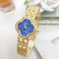 Dettaglio di un orologio al quarzo clover dorato con strass scintillanti e bracciale. - Cassa Oro Blu