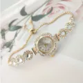 Closeup detail of the elegant gold quartz watch with sparkling rhinestones and a chic pull chain. - Gold White