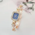 Elegante quadratische Damen Quarzuhr mit funkelnden Strasssteinen und zartem Blumen Armband Design. - Roségoldenes Gehäuse Blaues Zifferblatt