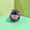 Close-up of cute capybara plush toy with ladybug backpack and metal keychain detail. - 12cm Bead Chain / Pink