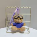 Cute flying bear plush doll pendant with goggles, soft stuffed toy keychain for backpacks. - Brown Bear in Purple Clothes