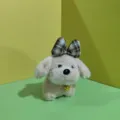 Vista dettagliata del cucciolo di peluche con un fiocco a quadri marrone e campanello dorato. - Anello diviso piatto da 12 cm / Beige