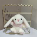 Schattige witte pluche konijn sleutelhanger met roze cape op een gouden displaystandaard. - 15 cm platte ring / Wit
