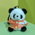 Plush panda keychain detail view, cute stuffed animal toy with orange knit sweater charm. - Black and Orange Sweater
