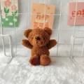 Close up detail of a cute brown plush bear toy pendant, fluffy texture and lovely sitting pose. - Brown Teddy Fleece Bear (Naked)