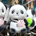 Nahaufnahme Detail von süßem Zeichentrick Panda Plüsch Schlüsselanhänger mit Rucksack. - Rosa Umhängetasche (Schlüsselanhänger)