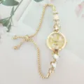 Gold-tone heart crystal quartz watch detail, adjustable pull chain strap, elegant dial design. - Gold