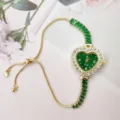 Green heart crystal watch detail showing rhinestone bezel and adjustable gold sliding chain. - Green