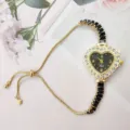 Close-up detail of a charming heart-shaped rhinestone women watch with a delicate pull chain. - Black