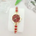 Nahaufnahme der Luxus Damen Quarzuhr mit rotem Edelstein Armband und Zifferblatt - Gold Rot